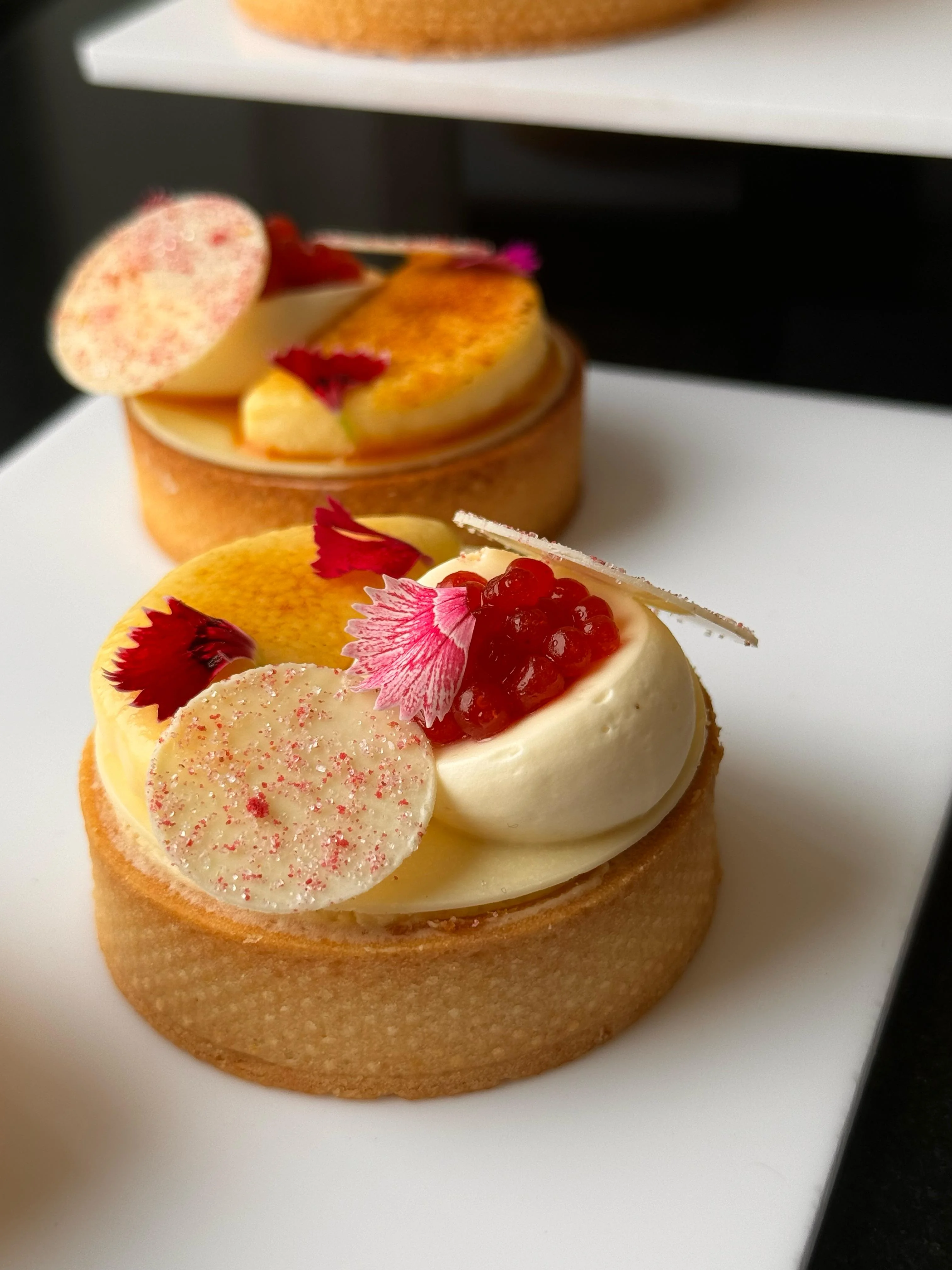Citrus Tartelette — golden sablé with citrus curd, vanilla cream dome, raspberry caviar and edible flowers, lined for service